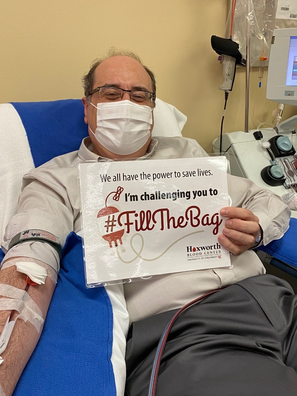 Dr. Jose Cancelas donating platelets, holding a "I completed the #FillTheBag Challenge" sign